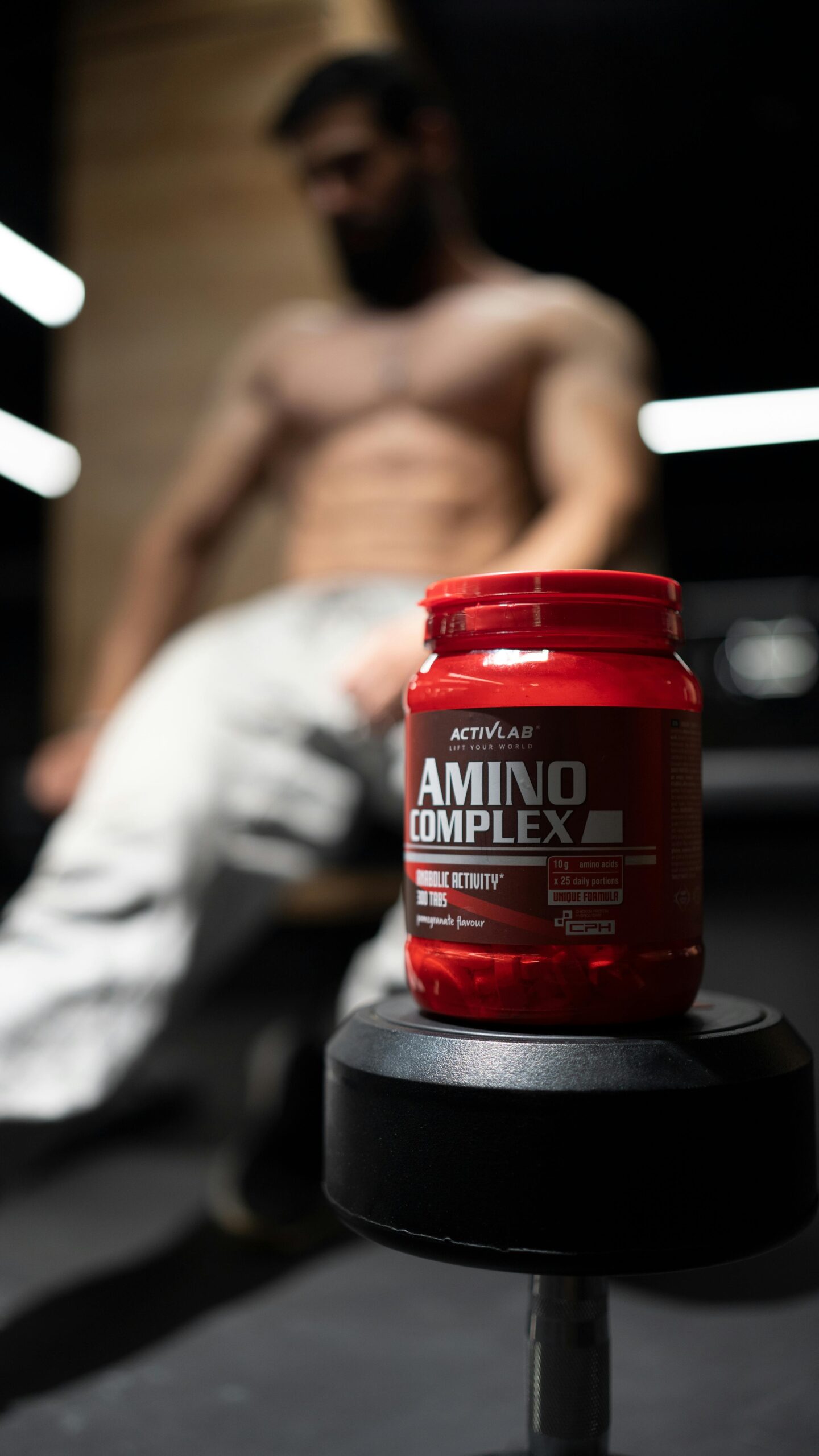 Body Builder sitting next to a creatine container